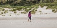 Pige går ved Blåvand Fyr i Naturpark Vesterhavet